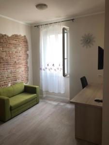 a living room with a green couch and a window at Villa Spalatina in Split