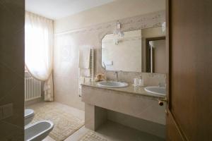 a bathroom with two sinks and a mirror and a toilet at La Casa di Pimpi in Desenzano del Garda