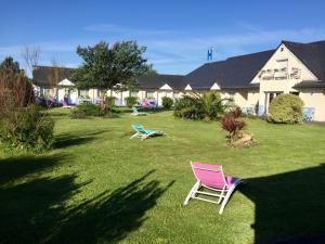 twee stoelen in het gras in een tuin bij Hôtel Heod - Binic - Saint-Quay-Portrieux in Étables