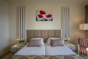 sypialnia z 2 łóżkami i obrazem na ścianie w obiekcie Aquamare Beach Hotel & Spa w Pafos