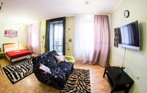 una sala de estar con una persona en una silla en RENT-сервис Apartment Zhukova 144 en Omsk