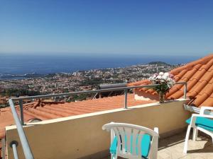 a balcony with chairs and a view of a city at The Hill View House in Funchal