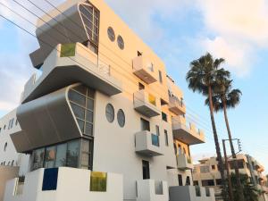 a building with a palm tree in front of it at Alex Residence in Larnaka