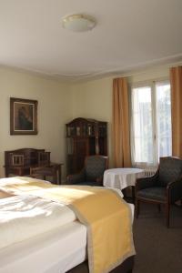 ein Hotelzimmer mit 2 Betten und 2 Stühlen in der Unterkunft Gasthaus zum Kreuz in Luzern