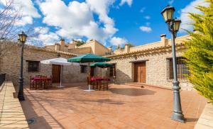 a patio with tables and umbrellas in front of a building at Finca La Celada in Moratalla