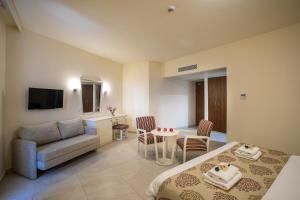 a hotel room with a bed and a couch at Aquamare Beach Hotel & Spa in Paphos