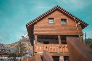 a wooden house with a balcony and a mountain at Apartmány Štefanova in Terchová