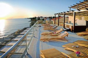een rij ligstoelen op het dek van een cruiseschip bij Hotel Delfin in Zadar