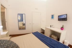 una camera da letto bianca con un letto e una scrivania di 319 al Duomo a Napoli
