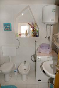 a white bathroom with a toilet and a sink at Apartment Piazzeta De Luxe in Split