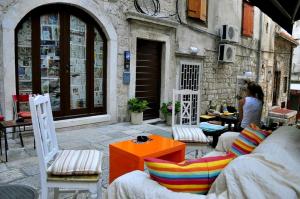a woman sitting at a table in front of a building at Apartment Piazzeta De Luxe in Split
