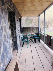 eine Veranda mit 2 Stühlen und einem Tisch in der Unterkunft Vichnashi in Mestia