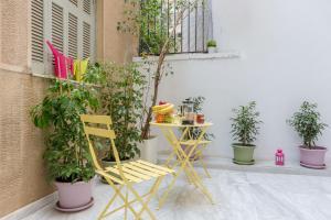 żółte krzesło, stół i kilka roślin w obiekcie Grandma's Chic & Bright Athenian home with a Patio w Atenach