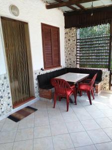 a patio with a table and two red chairs at Appartamenti Helvetia in Peschici