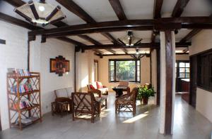 sala de estar con mesa y vigas y sillas de madera en Hotel La Vista, en Canoa