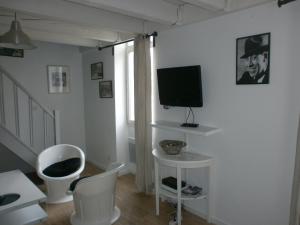 a living room with white furniture and a flat screen tv at Appartement du Palais Longchamps in Marseille