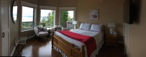 a bedroom with a bed with a red blanket at Bella Luna Bed and Breakfast in West Kelowna