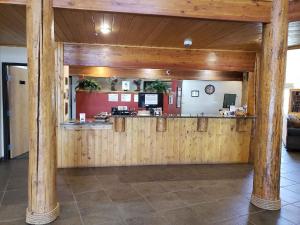 a bar in a restaurant with wooden walls at Cody Legacy Inn & Suites in Cody