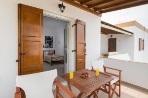 a dining room with a wooden table and chairs at Letta's Apartments in Finikas