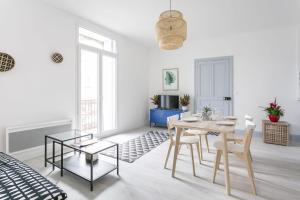 a white living room with a table and chairs at Sunny Relaxing Apartement in Béziers