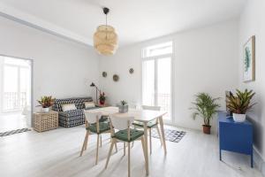 - un salon blanc avec une table et des chaises dans l'établissement Sunny Relaxing Apartement, à Béziers