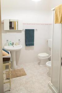 a bathroom with a toilet and a sink at By the Sea in Terrasini