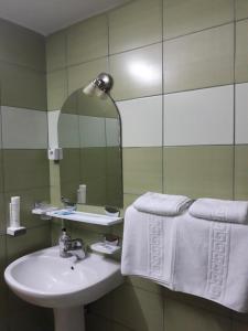 a bathroom with a sink and a mirror at Pensiunea Sydney in Timişoara