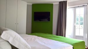 a bedroom with a green wall and a bed at Quinta do Cabo Guesthouse in Sintra