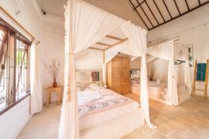 a bedroom with a bed with a canopy at Padang Padang Breeze in Uluwatu