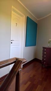 an empty room with a white door and a wooden floor at Quinta do Cabo Guesthouse in Sintra