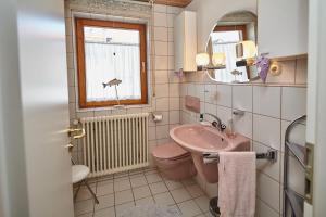 a bathroom with a pink toilet and a sink at BodenSEE Apartment Friedrichshafen SEENAH in Friedrichshafen