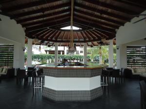 a bar in the middle of a restaurant with chairs at Sybaris Suites & Residences in Juan Dolio