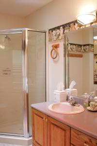 een badkamer met een wastafel en een douche bij Hummingbird Guesthouse in Port Alberni