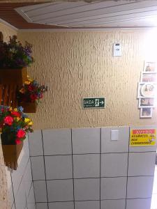 a sign on a wall with flowers on it at Hotel Fortaleza III Manaus in Manaus