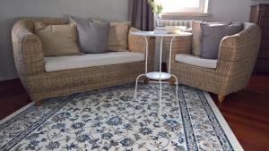 two wicker chairs and a table in a living room at Quinta do Cabo Guesthouse in Sintra