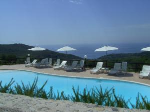 einen Pool mit Liegestühlen und Sonnenschirmen in der Unterkunft Resort Paradise Marina di Camerota in Marina di Camerota