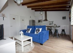 a living room with a blue couch and a table at Villas Las Catedrales in Ribadeo