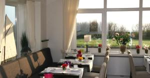 un comedor con mesas y sillas y una gran ventana en Miramar, en Helgoland