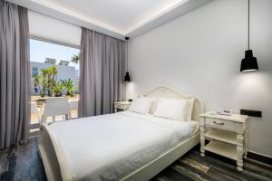 科斯镇Diamond Boutique Hotel的一间带床和阳台的白色卧室