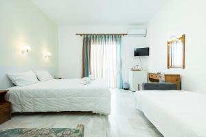 a hotel room with two beds and a television at Revekka Rooms in Kissamos