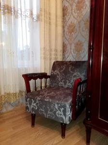 einem Stuhl vor einem Fenster mit Vorhängen in der Unterkunft Guesthouse Panorama in Kutaissi