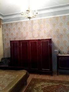 ein Schlafzimmer mit einem großen Holzschrank und einem Kronleuchter in der Unterkunft Guesthouse Panorama in Kutaissi