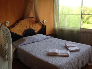 una camera da letto con un letto e due asciugamani di Hotel Des Sites a Salavas