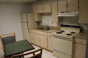 a kitchen with a stove and a sink and a table at Budget Inn - Charlotte in Charlotte