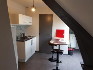 uma cozinha com uma mesa com um computador portátil vermelho em Appartement Hyper centre - Quartier du château de Vire em Vire