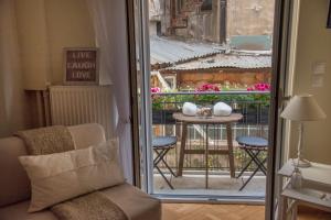 um quarto com uma varanda com uma mesa e uma janela em Living near Acropolis by Sylvia Staikou em Atenas