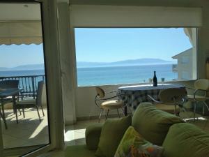 Sala de estar con sofá y mesa con vistas al océano en Luxury Sea View, en Ofrinion