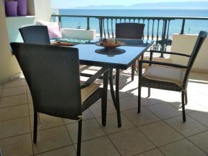una mesa y sillas en un balcón con vistas al océano en Luxury Sea View, en Ofrinion