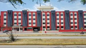 un grand bâtiment rouge avec une tour en haut dans l'établissement Hotel Madrid Minatitlán, à Minatitlán