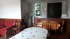 ein Esszimmer mit einem Tisch und einem roten Sofa in der Unterkunft Gîte Le Moulin de la Chaussee in Saint-Denis-dʼOrques